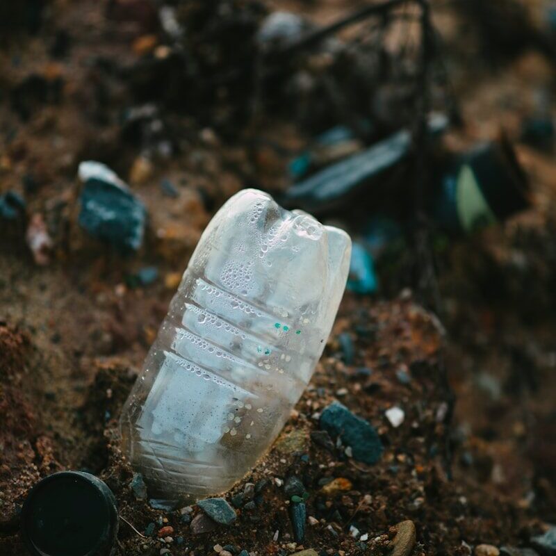 white plastic bottle on brown soil