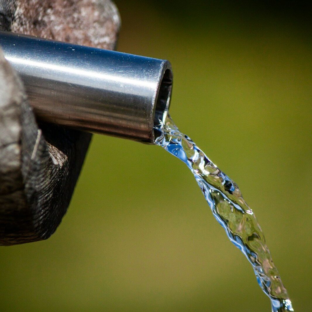 a close up of a metal faucet with water coming out of it